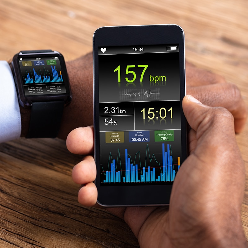 Man With Smartwatch And Cellphone Monitoring Heart Rate
